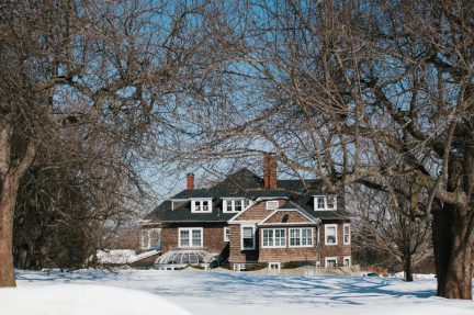 back view of mansion across snowy lawn