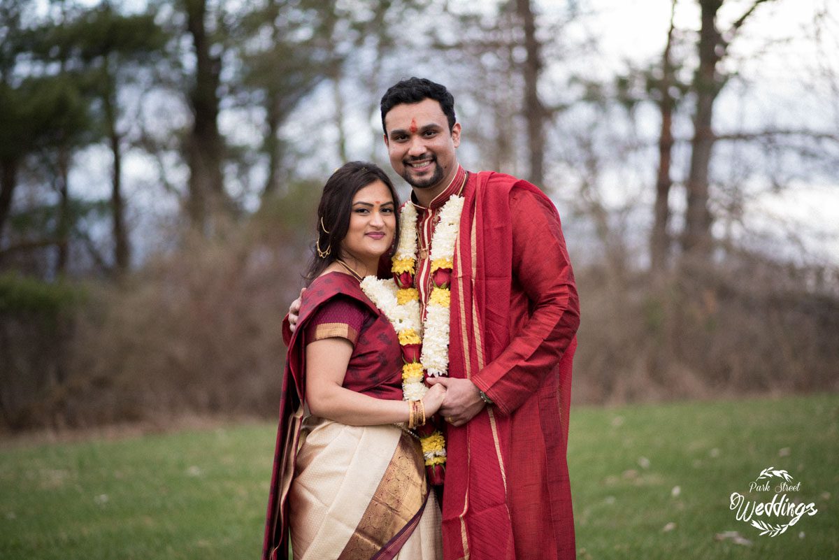 couuple-facing-the-camera-on-lawn-in-their-formal-indian wedding-attire