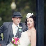 bride leaning on light post goom looking on