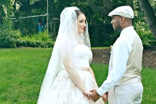 couple-facing-each-other-holding-hands-on-mansion-lawn