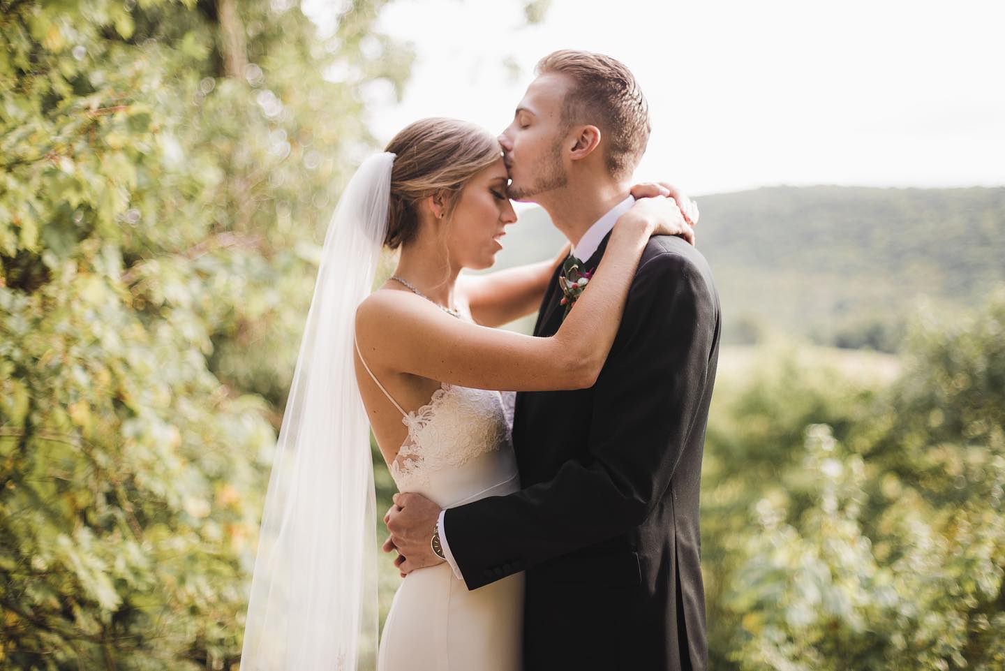 wedding-couple-embracing-with-hayfields-in-background